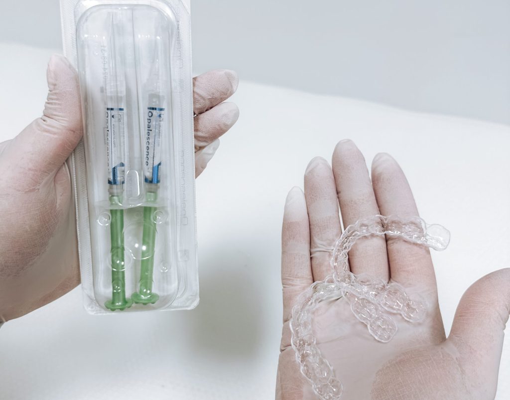 Dentist shows customized teeth whitening kit at OrthoDental