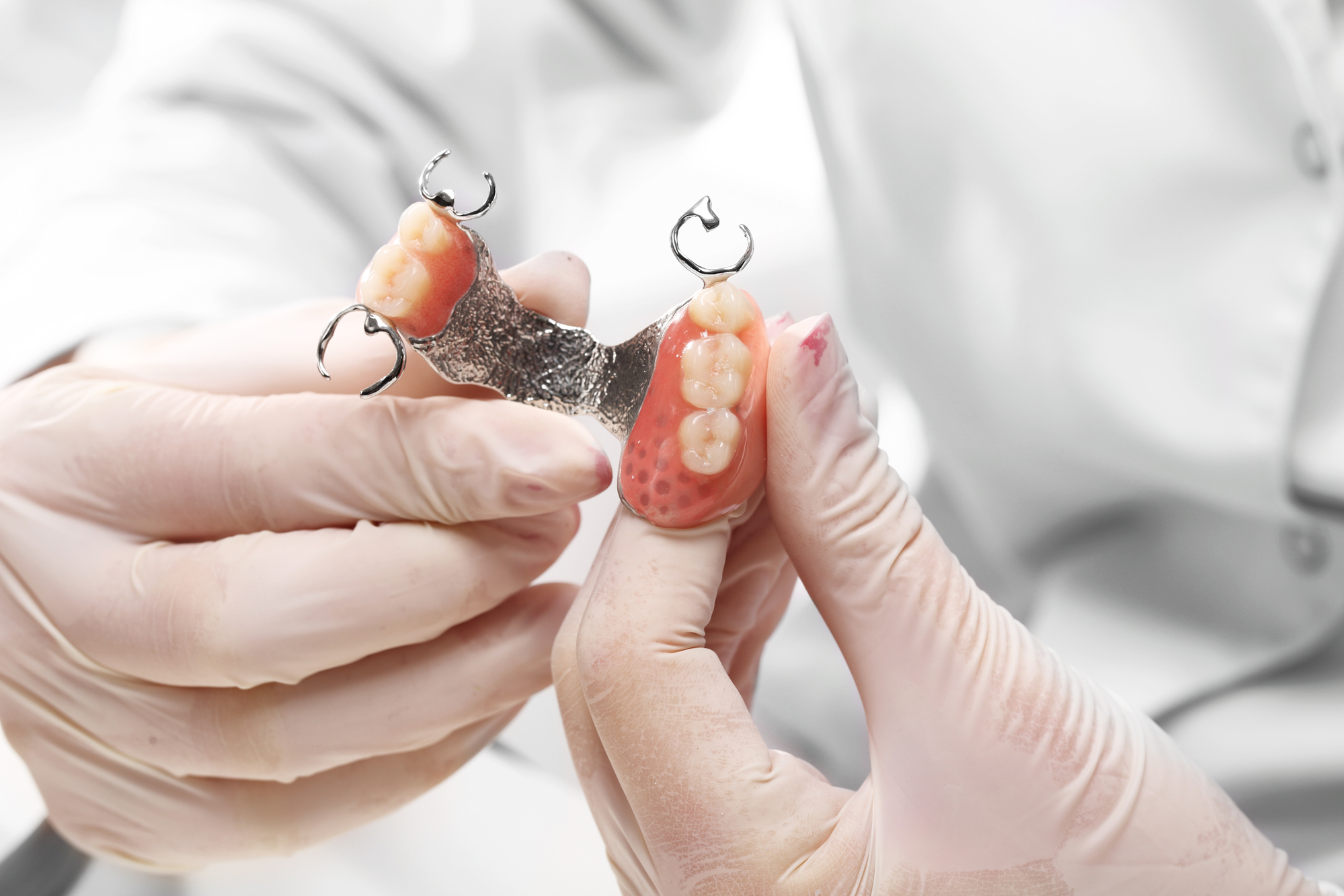Dentist holding and showing partial denture