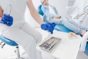 Dentist holding instruments during a dental check-up examination