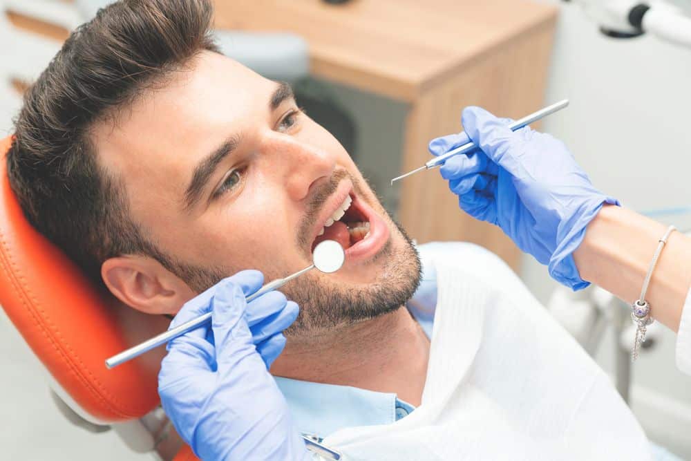Dentist performing a routine check-up on a patient