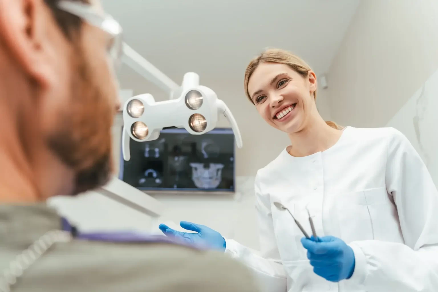 A friendly dentist explaining local anaesthesia to a patient