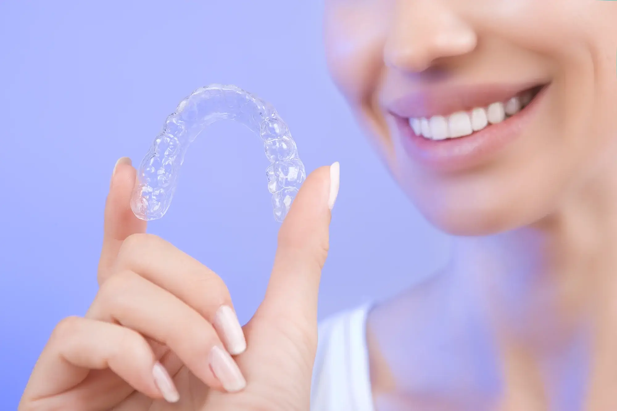 Patient holding at-home teeth whitening trays