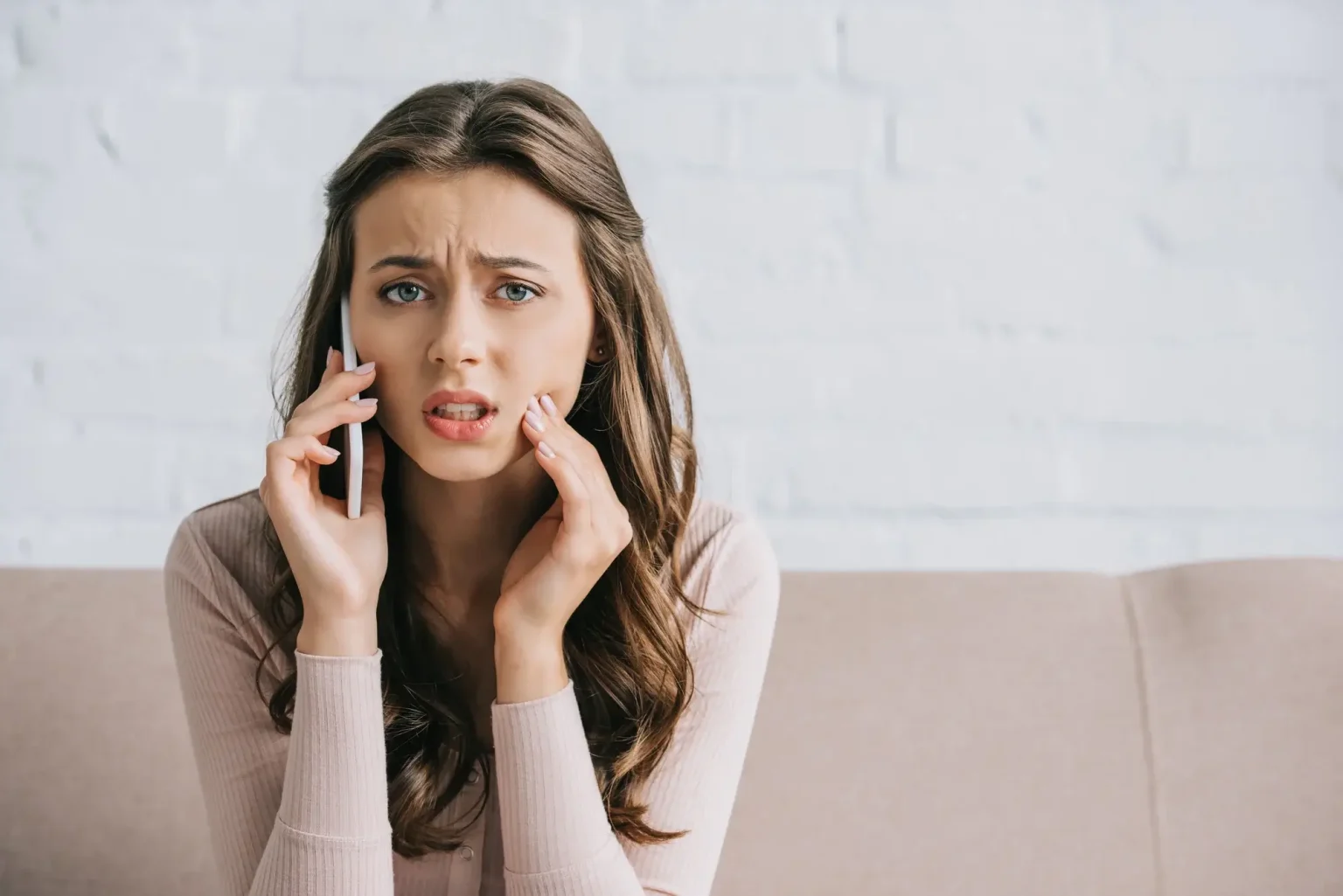 A person with a toothache holding their cheek