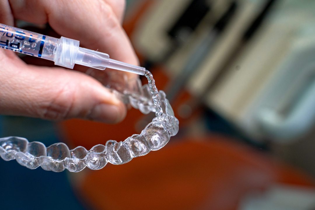 Patient preparing teeth whitening kit at home
